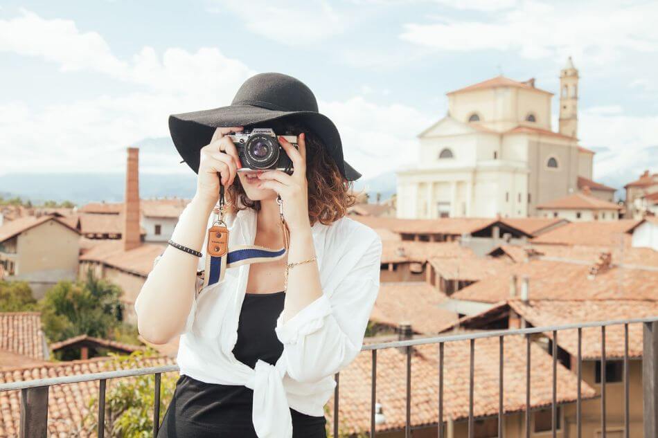 woman in hat taking photo with camera 1