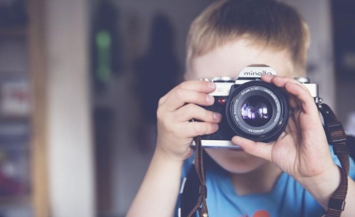 kid holding camera