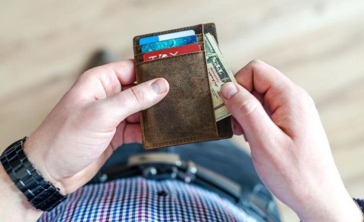 photo of man with cash in wallet
