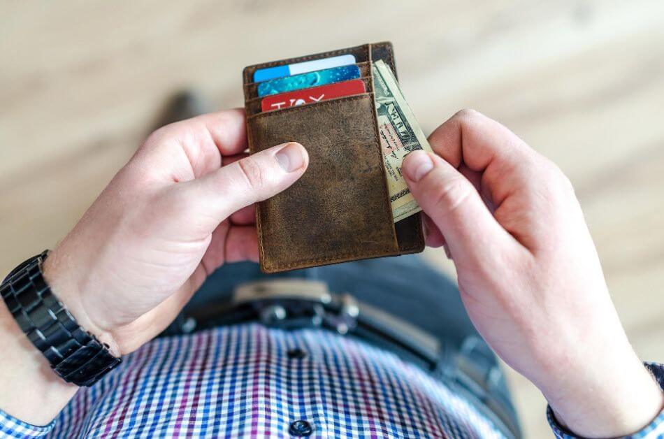 photo of man with cash in wallet