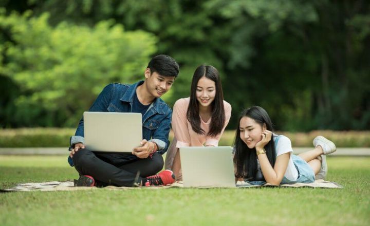 students on grass with laptops 1